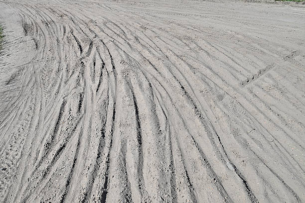 istock Multiple Bicycle tire tracks  in a sandy road 2206655125