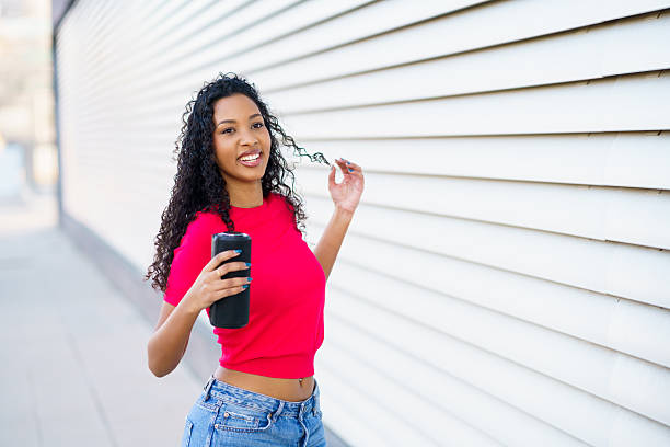 istock A Young Woman Enjoying a Lovely and Sunny Day While Using Her Smartphone and Smiling 2206655888
