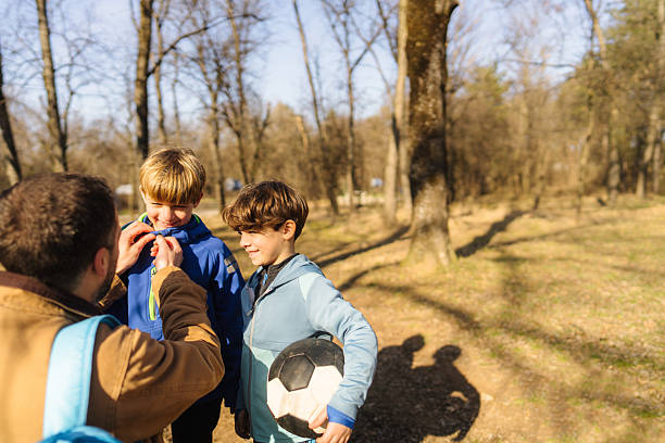 Photo of father and his sons spending a day in nature together