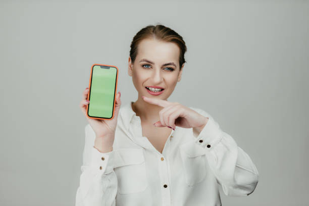 istock Businesswoman Presenting Smartphone with Green Screen 2206660335