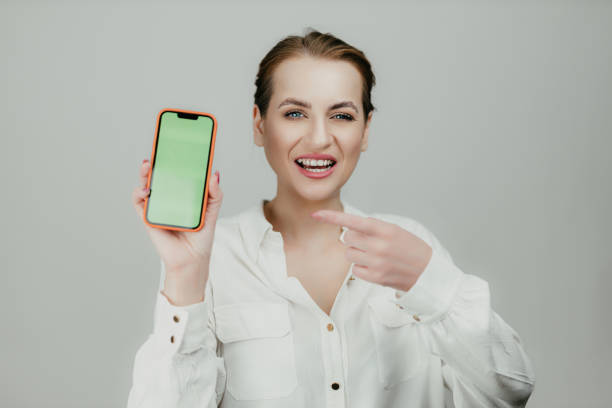 Businesswoman Presenting Smartphone with Green Screen