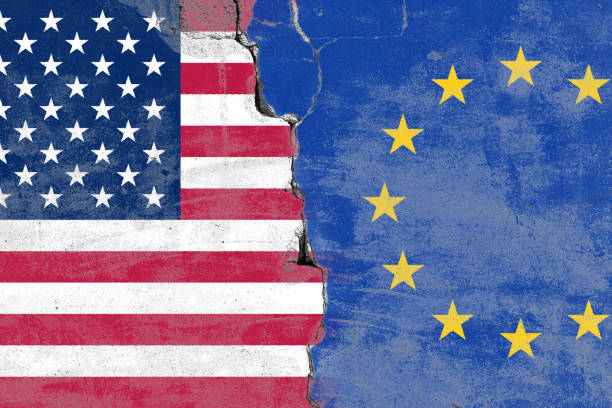 istock Cracked wall separating USA and EU flags 2206665395