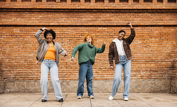 istock Three young women dancing in the street 2206666641