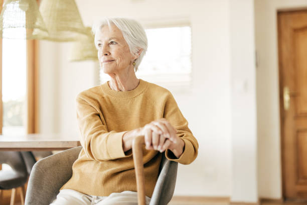 istock Empowered aging concept shown through a radiant, white-haired woman smiling in a comfortable home environment. 2206669526