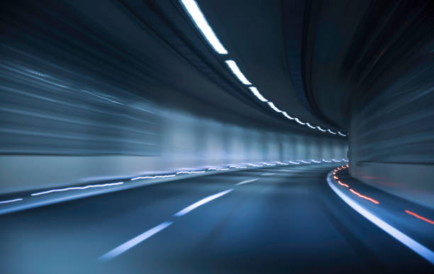 istock Dynamic movement captures the thrill of driving through a curving tunnel at night with illuminated walls creating a vibrant atmosphere 2206670641