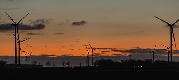 istock wind turbines at night set against dark orange sky in Netherlands 2206670985