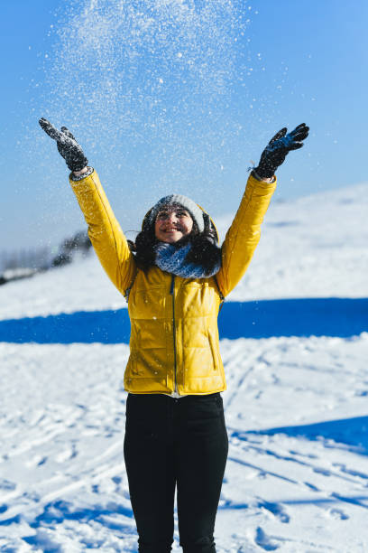 istock Cheerful Female Throwing Snow Over Her Head Smiling and Enjoying 2206672807