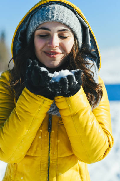 Beautiful Female Making Wish With Closed Eyes Before Blowing Snow