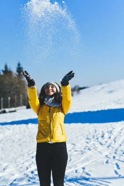 istock Happy Female Having Fun on Sunny Mountain Throwing Snow Over Her Head 2206673199