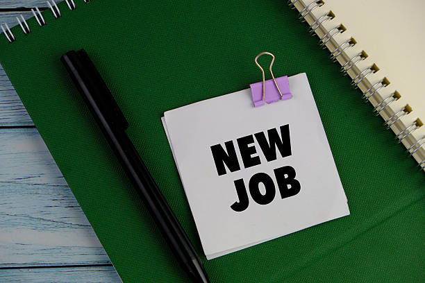 istock white note pad on green background. Text of NEW JOB. 2206673342