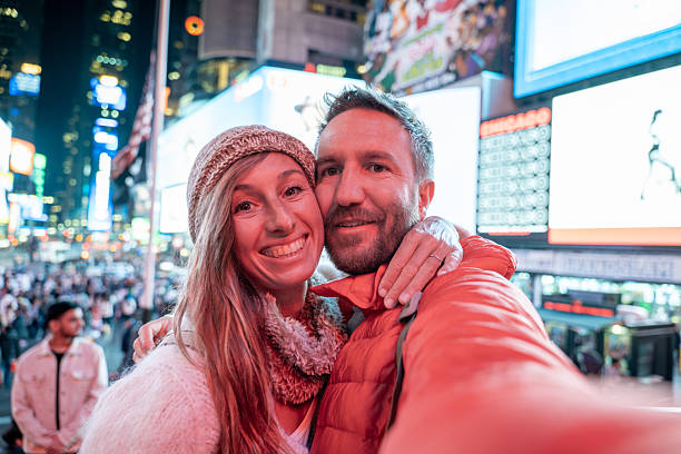 istock Smiling Couple Taking Selfie in Times Square at Night 2206674169