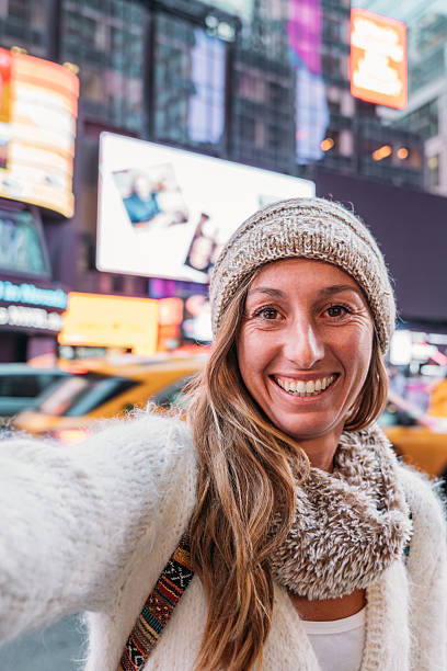 istock Woman Taking Selfie in Times Square with Bright Billboards 2206674171