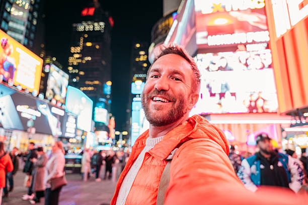 istock Man Taking Selfie in Vibrant Times Square at Night 2206674218