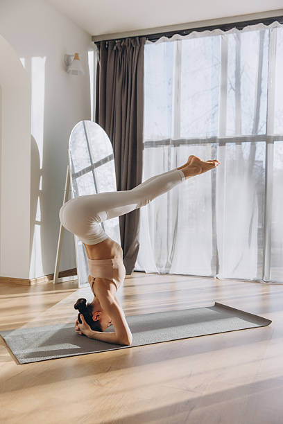 istock Young woman practicing supported headstand yoga pose at home 2206674275