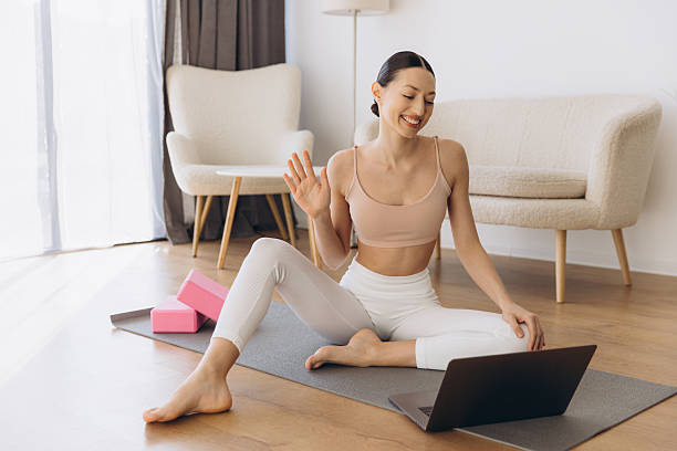 istock Yoga instructor waving at laptop during online class at home 2206675608