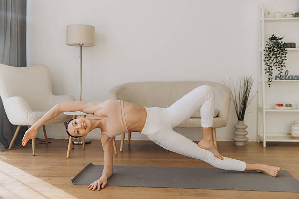 istock Young woman practicing Vasisthasana yoga pose at home 2206676963