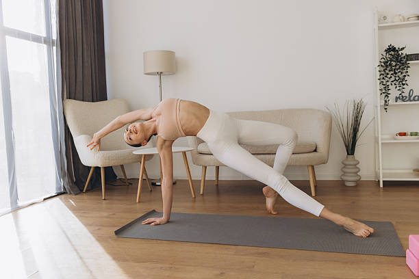 istock Young woman practicing yoga side plank pose variation at home 2206677059
