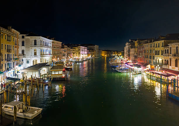 Venice, Italy - 14 March 2025 - The city on the sea, with the most characteristic places and touristic attractions in the world, during blue hour and night. Here in particular: the view of Canal Grande from the Rialto bridge.