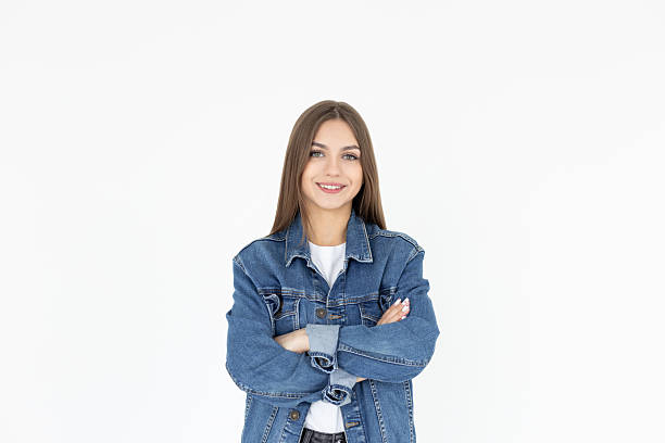istock Image of cheerful woman in basic t-shirt and jeans coat smiling at camera while standing with arms crossed isolated over white background 2206679907