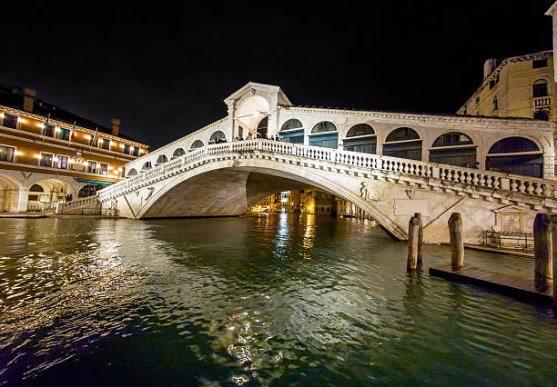 Venice, Italy - 14 March 2025 - The city on the sea, with the most characteristic places and touristic attractions in the world, during blue hour and night. Here in particular: the Rialto bridge.