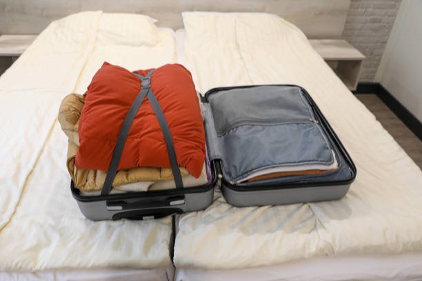 istock Open Suitcase with Neatly Packed Items on a Bed in a Bedroom 2206680245