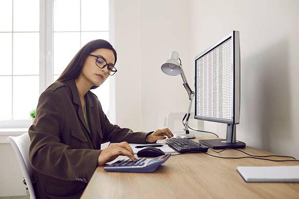 istock Serious business accountant in glasses working in office and using computer and calculator 2206680259