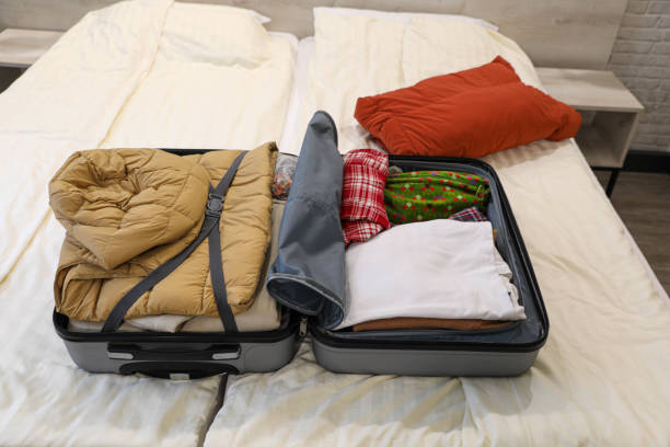 istock Open Suitcase with Neatly Packed Items on a Bed in a Bedroom 2206680271