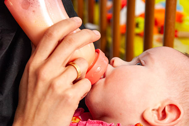 close up of young blond mother Bottle feeding the baby