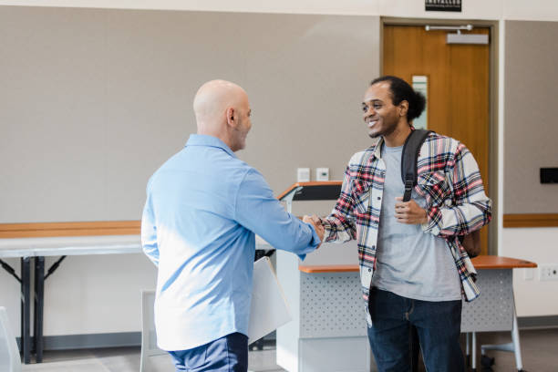 istock Professor and Student Handshake in University Classroom 2206686192