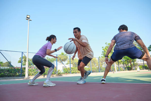 istock Multiracial people practicing basketball against blue sky 2206686746
