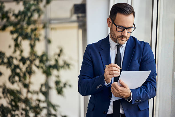 istock Professional Businessman Reviewing Documents Near the Window in an Office Setting 2206687079