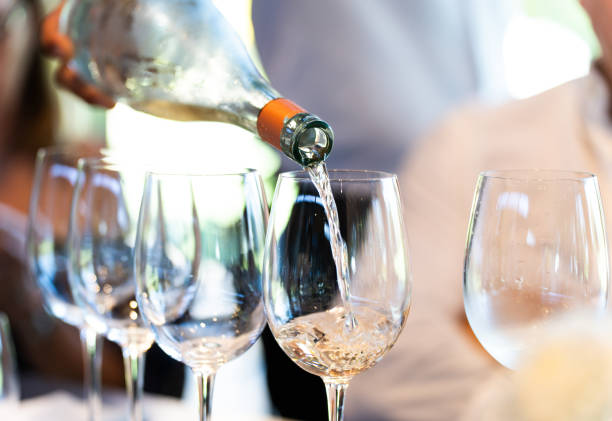 istock A waiter serves a glass of white wine 2206687251