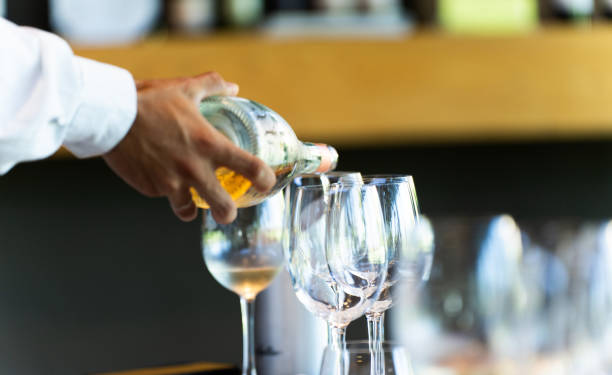 istock A waiter serves a glass of white wine 2206687296
