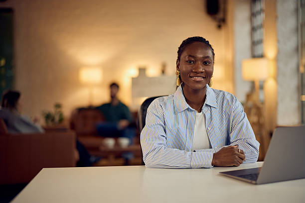 istock Confident Woman Smiling While Sitting With a Laptop in Modern Workspace 2206689400