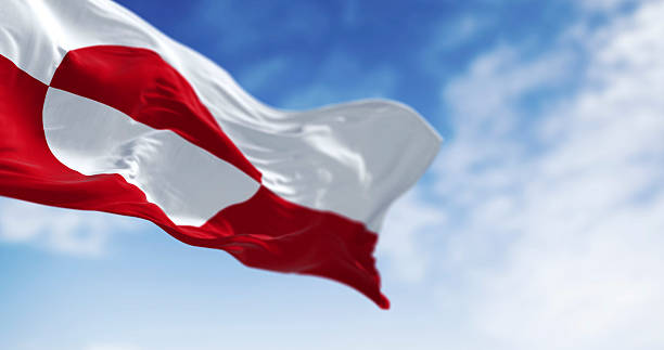 istock Greenland flag waving against clear blue sky, 3D render 2206690446