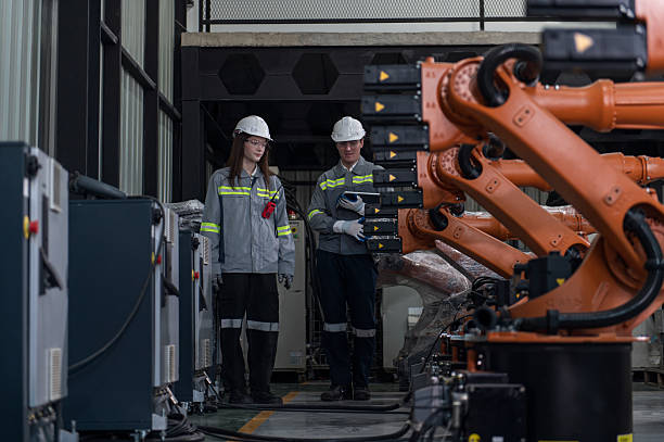 istock Engineer standing by robotic arm and operating machine in industry factory, technician worker check for repair maintenance electronic operation 2206690880