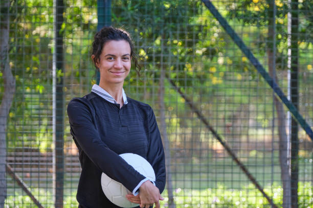 istock Smiling female player standing with basketball 2206690900