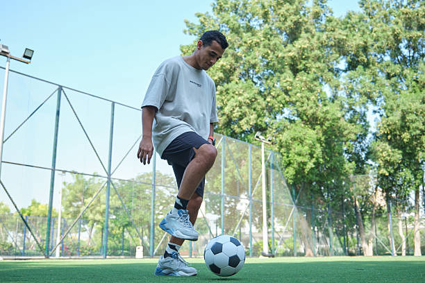 istock Low angle view of man playing soccer at turf 2206691619