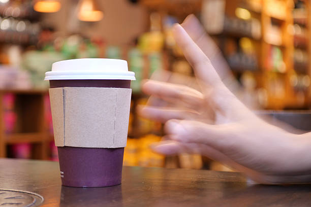 A hand reaches for a coffee cup in a cozy cafe, inviting comfort and relaxation