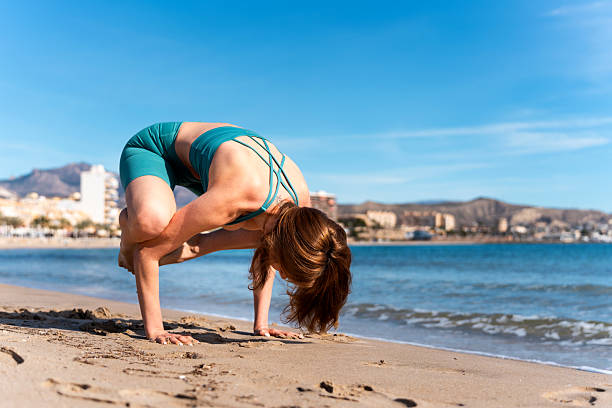 istock Ukrainian woman practicing yoga handstand pose on spanish beach 2206691827