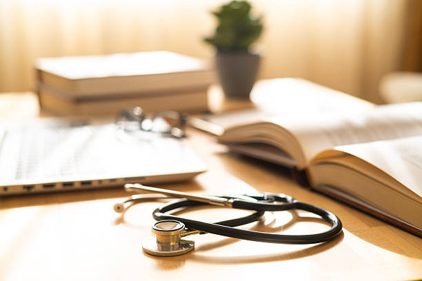 hospital work environment featuring medical notepad and stethoscope, reflecting professional patient care and dedication - doktor ofisi stok fotoğraflar ve resimler