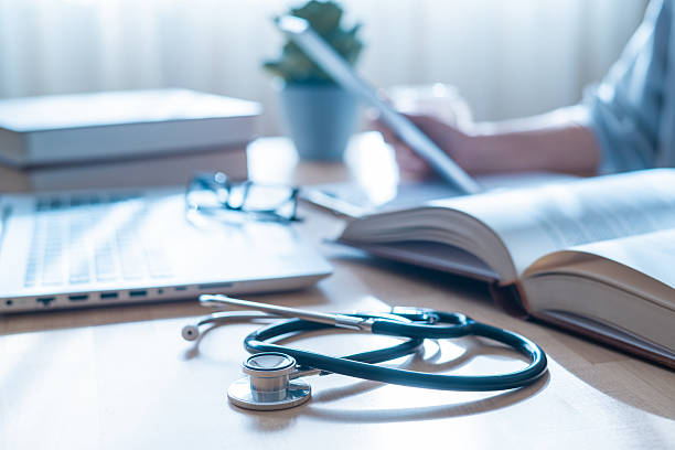 istock Medical Science And Healthcare Concept With Stethoscope, Doctor Writing On Notebook, Using Laptop In Bright Office, Research, Innovation, Wellness, Telemedicine And Modern Health Solutions 2206693071