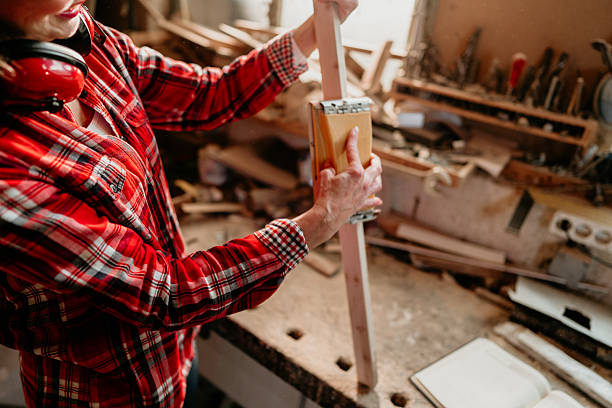 istock Carpenter sanding wooden plank in workshop 2206693139