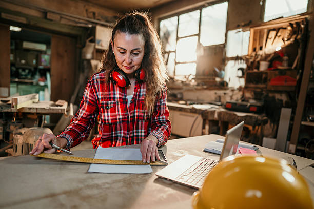 istock Carpenter measuring wood with ruler and pencil in workshop 2206693426