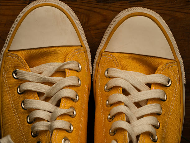 Yellow pump sneakers with laces close up selective focus