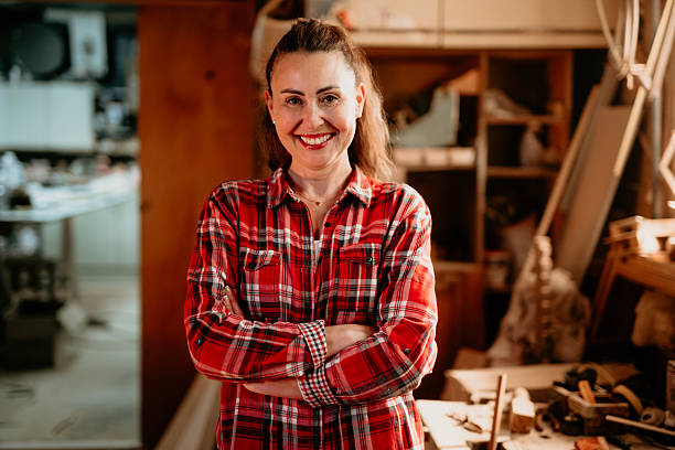 istock Confident female carpenter smiling with folded arms in workshop 2206693781