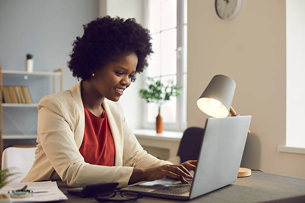 istock Young afro american businesswoman working on laptop with electronic documents. 2206696709