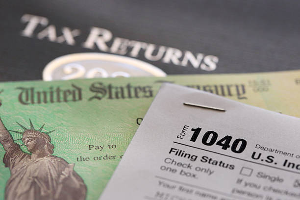istock Tax Refund Check Resting On An IRS 1040 Tax Form 2206697363
