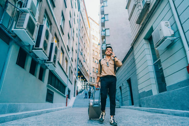 istock Tourist with suitcase is talking on the phone 2206698984