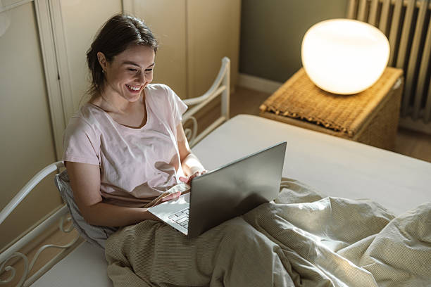 istock Smiling woman journaling on bed during relaxing morning sunlight 2206699240